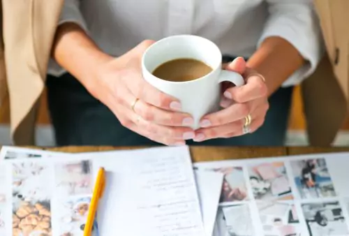 Woman holding a cup of coffee while working